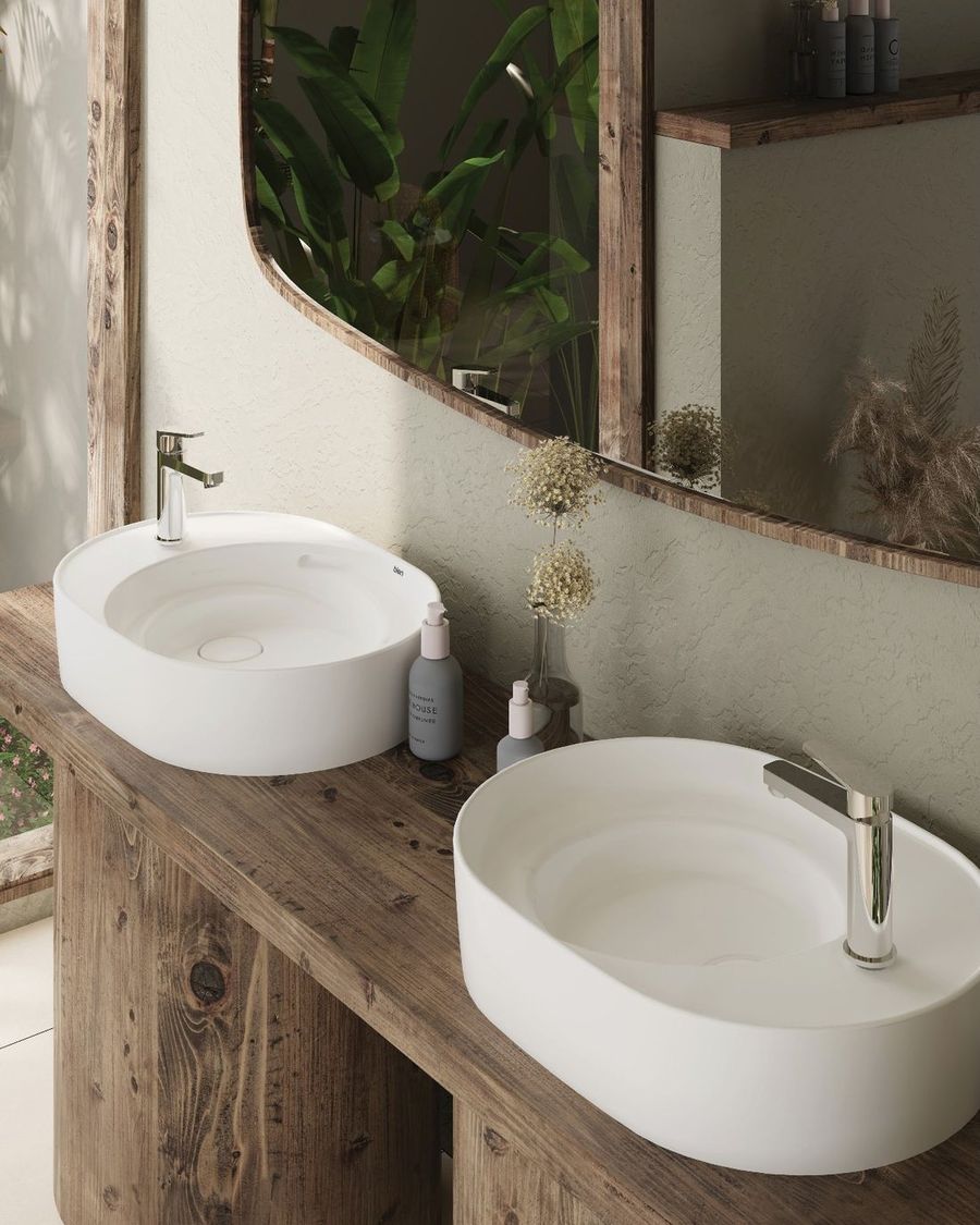 Ahşap tezgah üzerinde iki oval tezgah üstü lavabo